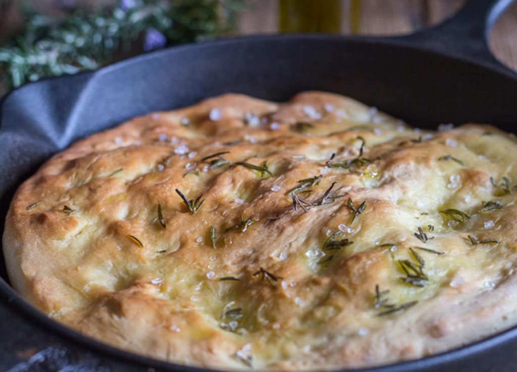 Baked focaccia in a black pan.