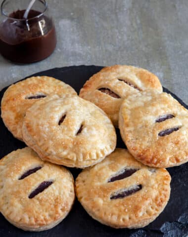 Hand pies on a black plate.