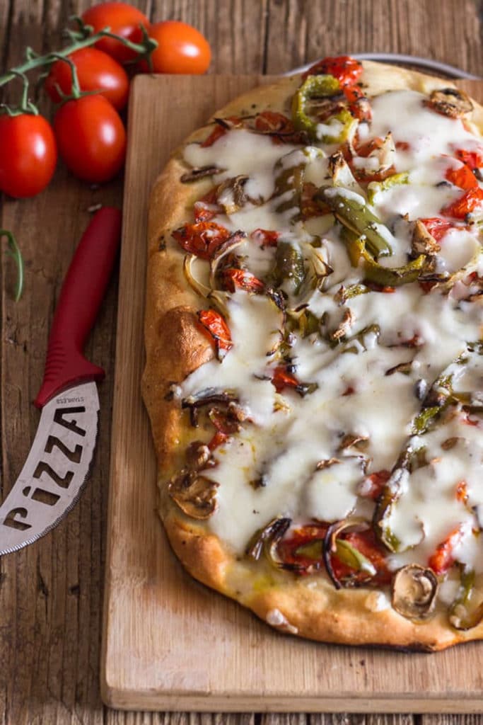 Baked pizza on a wooden board.
