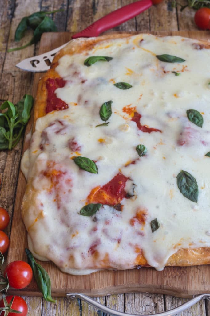Tomato & mozzarella pizza on a wooden board.