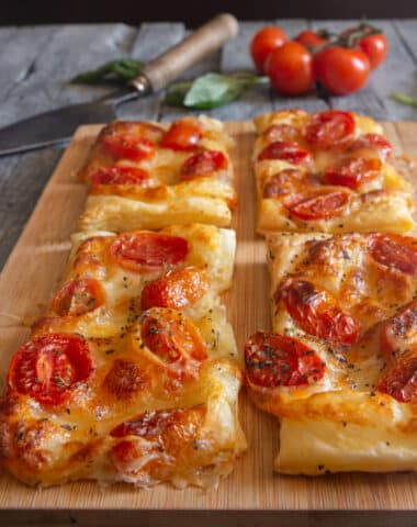 Puff pastry tomato appetizers on parchment paper.