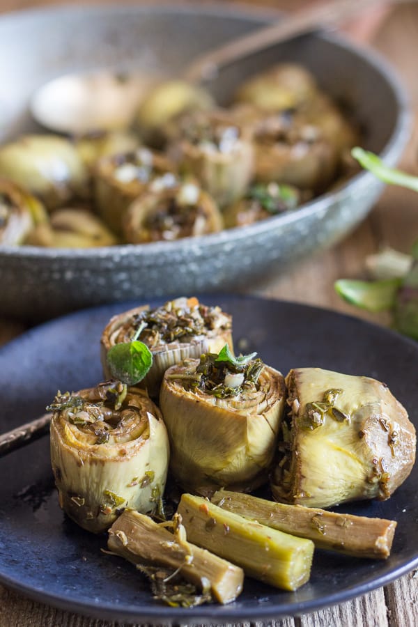 cooked roman artichokes in a pan and 3 on a plate